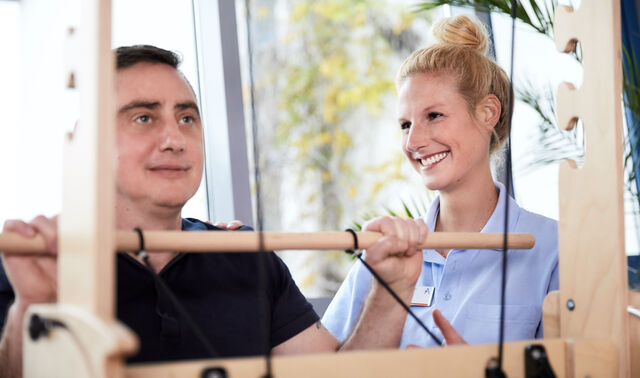 Das Bild zeigt einen Patienten und eine begleitende Trainerin bei der neurologischen Reha  