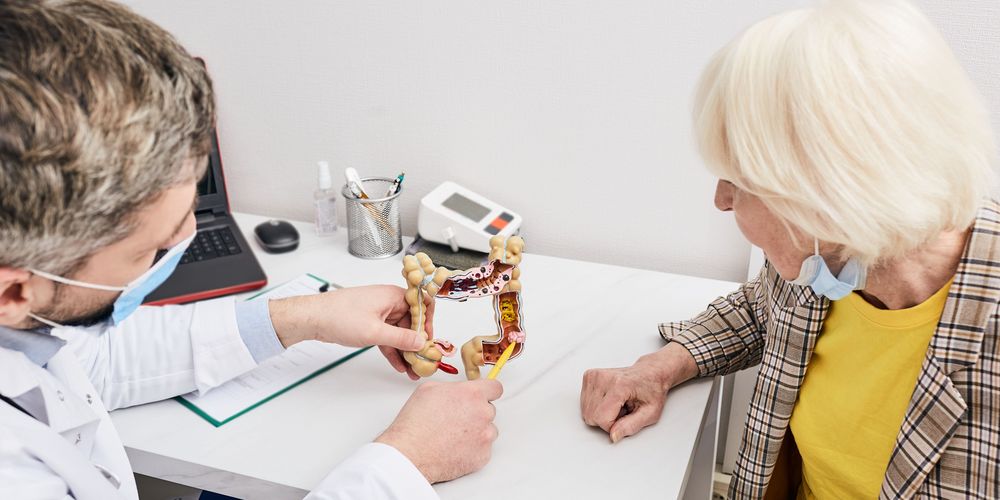 Ein Arzt erklärt einer Patientin die mögliche Behandlung bei Darmkrebs. 
