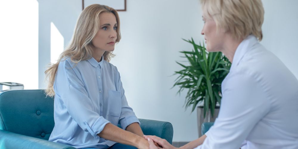 Eine Therapeutin hilft einer Betroffenen in einer Therapie, mit ihrer Angst umzugehen. 