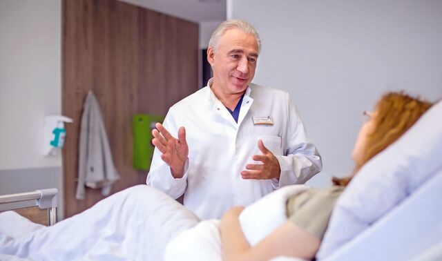 Ein Arzt aus dem Fachbereich Ambulanz erklärt einer Patientin den Ablauf der Behandlung.