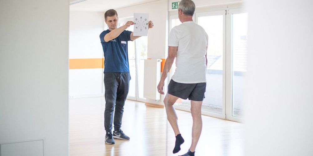 Ein Patient der neurologischen Reha bei der Therapiestunde mit einem Therapeuten. 