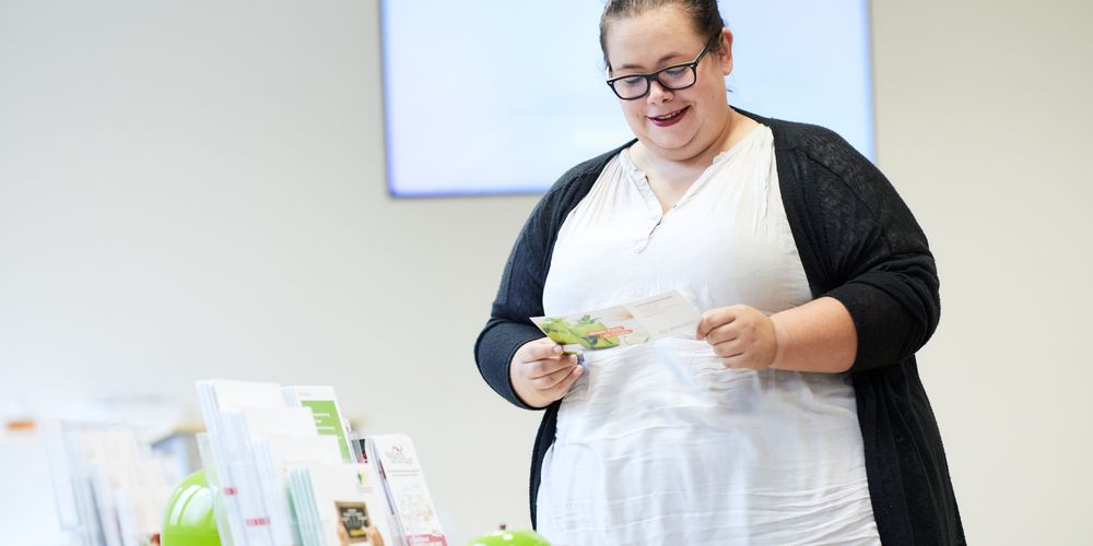 Eine übergewichtige Frau informiert sich darüber, was alles zur Adipositas-Behandlung gehört. 
