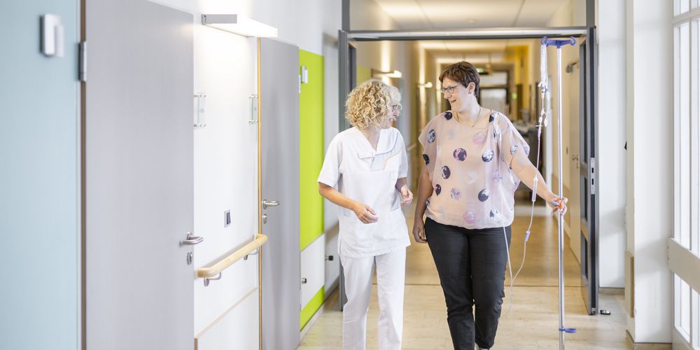 Pflegerin betreut eine Patientin während und nach der Chemotherapie in der Reha.