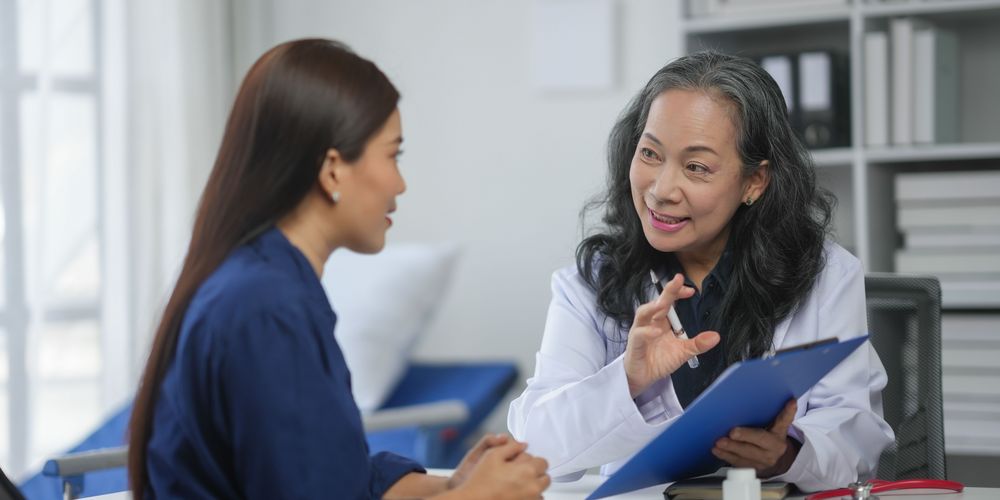 Eine Ärztin erklärt einer Patientin wie die Behandlung einer Blasenschwäche oder Harninkontinenz aussieht.