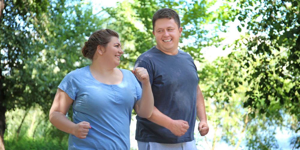 Zwei Freunde joggen gemeinsam, um ihre Adipositas Ernährungstherapie mit ausreichend Bewegung zu unterstützen. 