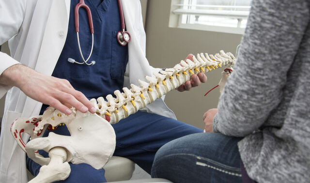 An einem Skelettmodell wird eine Erkrankung aus dem Fachbereich Orthopädie erklärt.