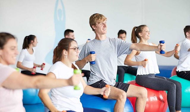 Ein Kurs übt gemeinsam Gesundheitssport aus.