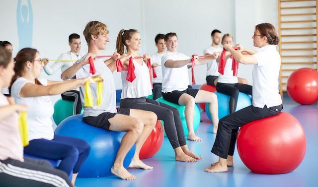 Eine Übungsleiterin und Teilnehmende bei einer Übungseinheit im Rahmen von Rehasport.