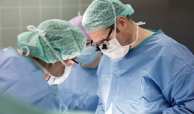 Zwei Ärzte an einem Operationstisch in einem Operationssaal 