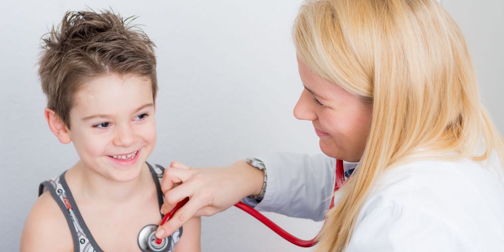 Eine Ärztin untersucht einen jungen Patienten.