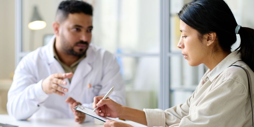 Ein Facharzt für Thoraxchirurgie berät eine Patientin über die Behandlungen.