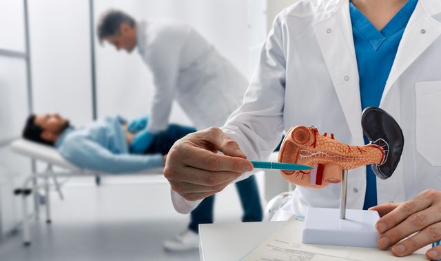 Ein Arzt untersucht einen Patienten und stellt die Diagnose Bauchspeicheldrüsenkrebs.