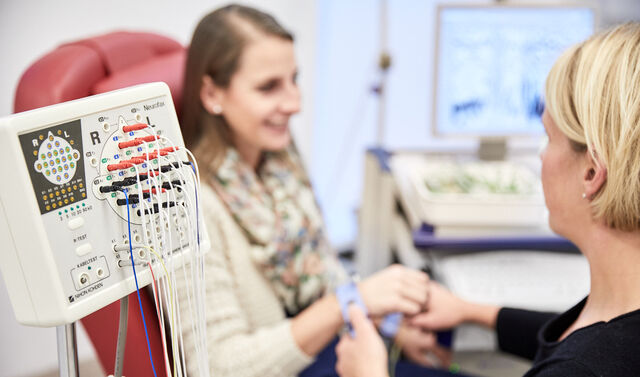 Das Bild zeigt eine Mitarbeiterin bei der ambulanten Behandlung einer Patientin.