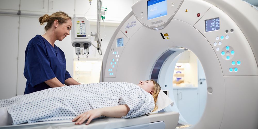 Ein Arzt bereitet ein CT-Scan vor, der genaue Bilder des Gehirns liefern soll, um eine Hirnblutung festzustellen.