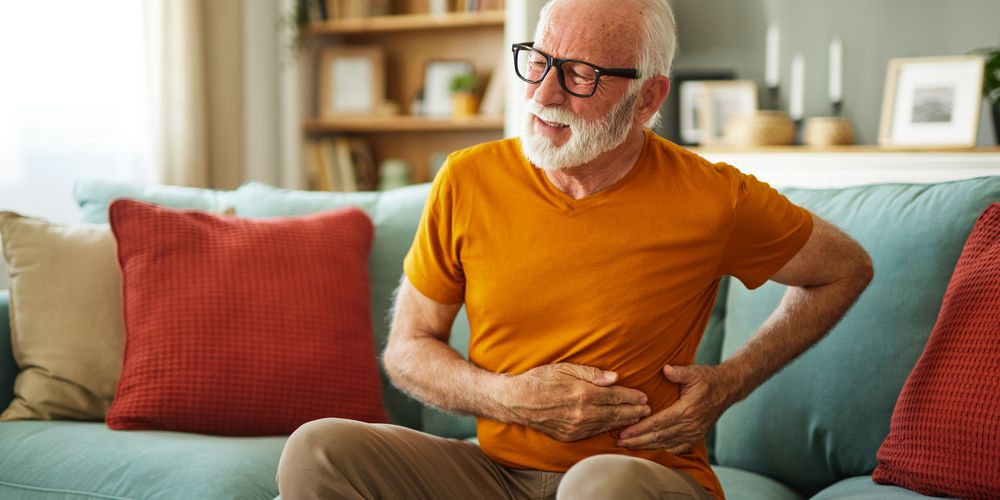 Ein Mann leidet unter Bauchschmerzen, ein Symptom für eine Darmentzündung.