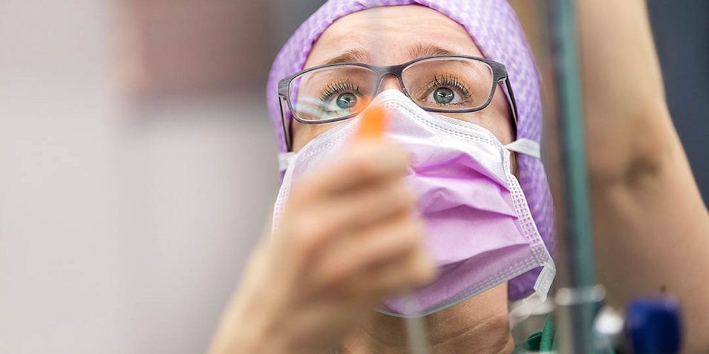 Eine Mitarbeiterin der Chirurgie versorgt einen Patienten während einer Operation.