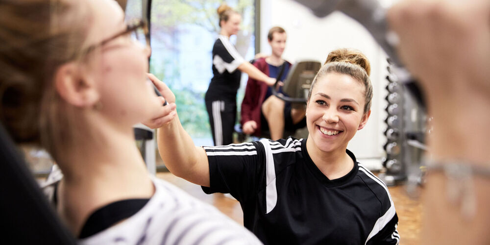 Eine Therapeutin betreut eine Patientin beim therapeutischen Training.