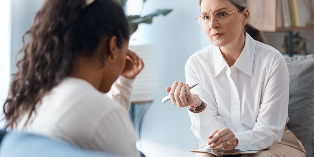 Die Grafik zeigt eine betroffene Person in einer Psychotherapie.