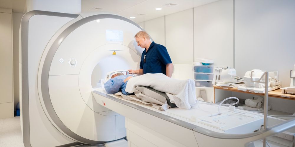 Die Grafik zeigt einen Arzt, der einen Patienten mit Schädel-Hirn-Trauma im MRT betreut.