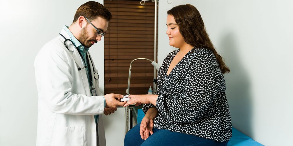 Eine Patientin wird von einem Arzt untersucht, um die Eignung für die Bewegungstherapie bei Adipositas festzustellen.