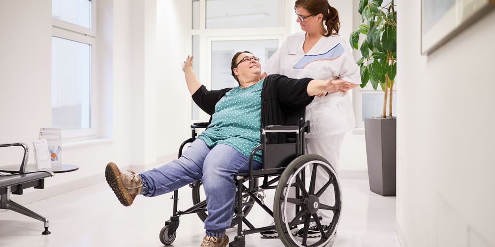 Eine Frau bespricht mit einer Patientin, die im Rollstuhl sitzt, deren Motivation und Gründe für einen Magenbypass.