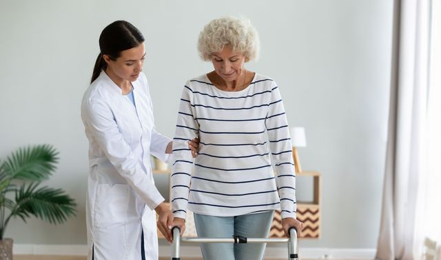 Eine Ärztin hilft einer Patientin beim Gehen.