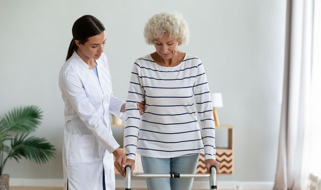 Eine Ärztin hilft einer Patientin beim Gehen.