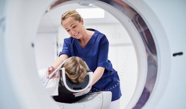 Eine Pflegerin beruhigt einen Patienten vor seiner Strahlentherapie gegen Krebs.