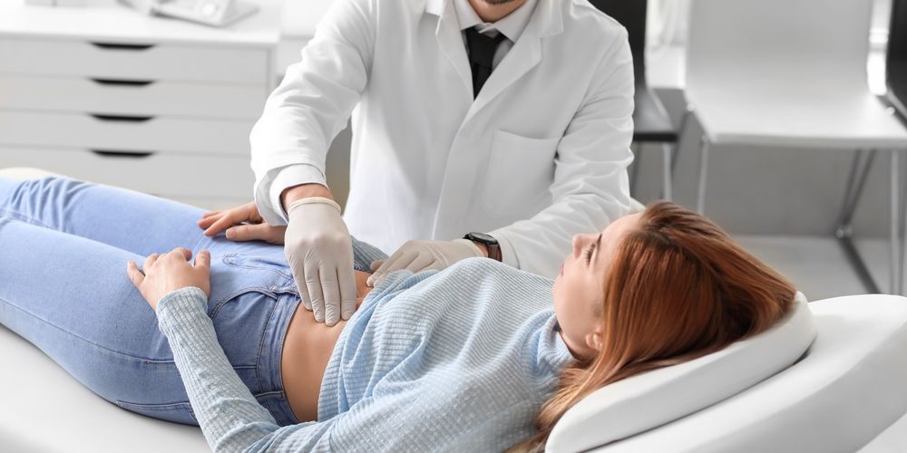 Ein Arzt untersucht eine Patientin zur Behandlung ihres Bauchwandbruchs.
