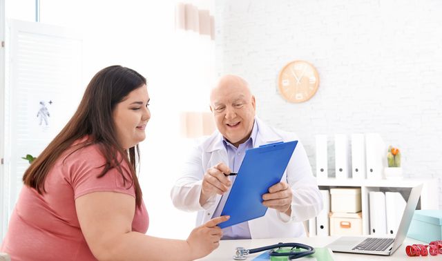 Eine übergewichtige Frau informiert sich bei ihrem Arzt über eine Magenverkleinerung.