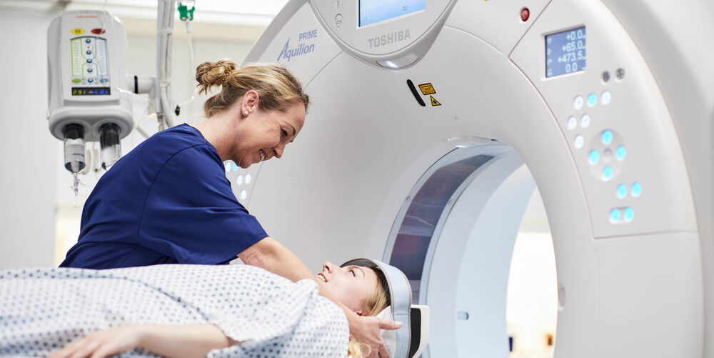Was ist Neuroradiologie? Eine Mitarbeiterin der Neuroradiologie bereitet eine Patientin für die Computertomographie vor.
