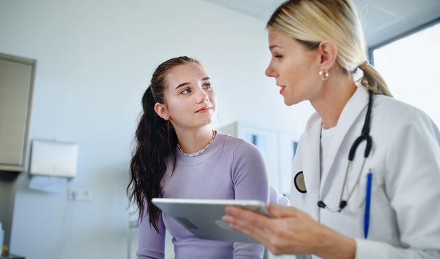 Eine Ärztin klärt ihre junge Patientin über den Blinddarm und mögliche Beschwerden auf.
