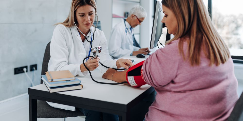 Eine Patientin wird von einer Ärztin untersucht, um festzustellen, ob das Abnehmen ohne OP möglich ist. 