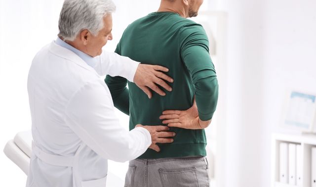 Ein Arzt befragt einen Patienten über die Symptome seines möglichen Hexenschusses.