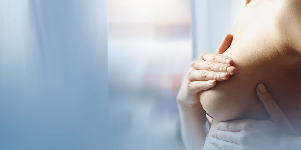 Modernste Technik bei der gynäkologischen Diagnostik Eine Frau, die ihre Brust abtastet, repräsentiert eine typische Patientin in der Gynäkologie.