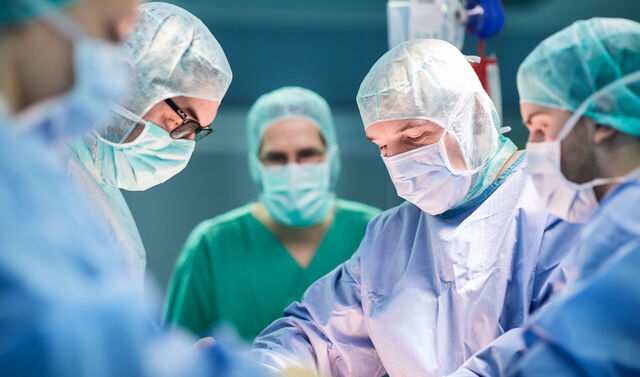 Ein Arzt sowie das medizinische Team der Orthopädie nehmen eine Operation an einem Patienten vor.