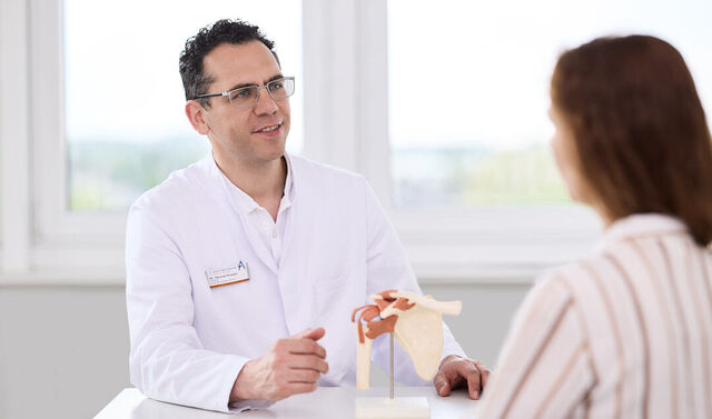 Ein Facharzt behandelt eine Patientin in der Orthopädie-Ambulanz.