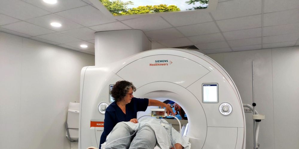 Eine Mitarbeiterin der Wirbelsäulenchirurgie bereitet eine Patientin auf eine Untersuchung im MRT vor.