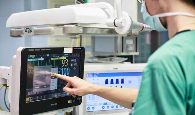 Ein Mitarbeiter der Wirbelsäulenchirurgie überprüft die Vitalwerte eines Patienten während der Operation.