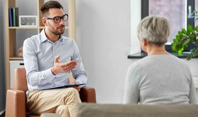 Ein Arzt berät eine betroffene Frau und informiert sie darüber, was eine Depression ist.