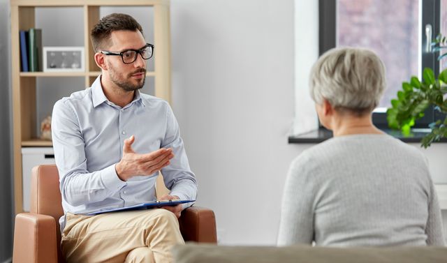Ein Arzt berät eine betroffene Frau und informiert sie darüber, was eine Depression ist.