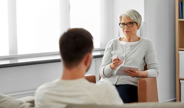 Man sieht eine Therapeutin, die mit einer Person über die Symptome einer bipolaren Störung spricht.