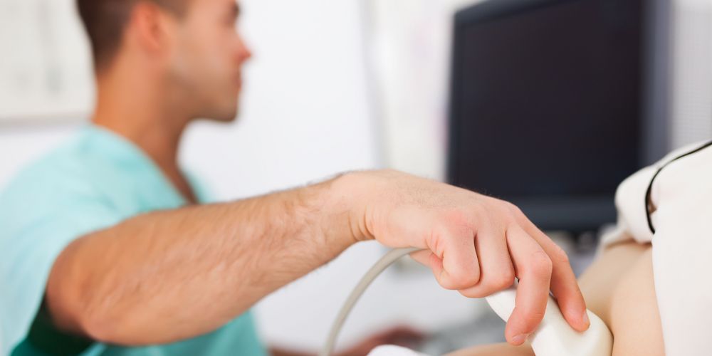 Ein Arzt untersucht per Ultraschall den Bauch einer Frau zur Diagnose eines Bauchwandbruchs.