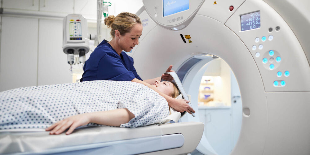 Eine Mitarbeiterin der Psychosomatik bereitet eine Patientin für ein MRT vor. 