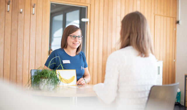 Eine Logopädin eine Patientin beim therapeutischen Training.