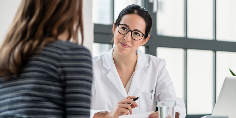 Eine Ärztin erklärt einer Patientin die Ursachen für Dranginkontinenz.