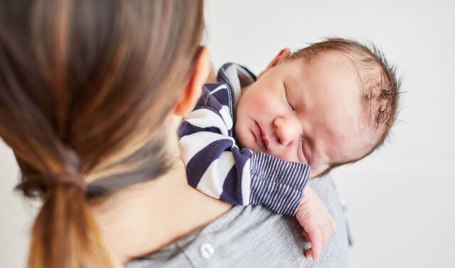 Eine Mutter hält ihr schlafendes Baby.