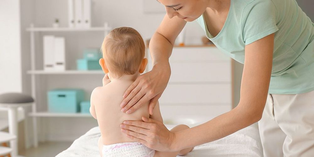 Fachärztin für Kinderorthopädie untersucht ein Kind auf Fehlstellungen.