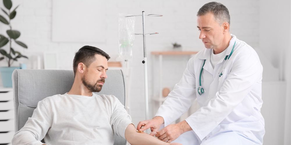 Ein Patient erhält nach der Kyphoplastie-Behandlung kompetente Unterstützung durch einen Arzt.
