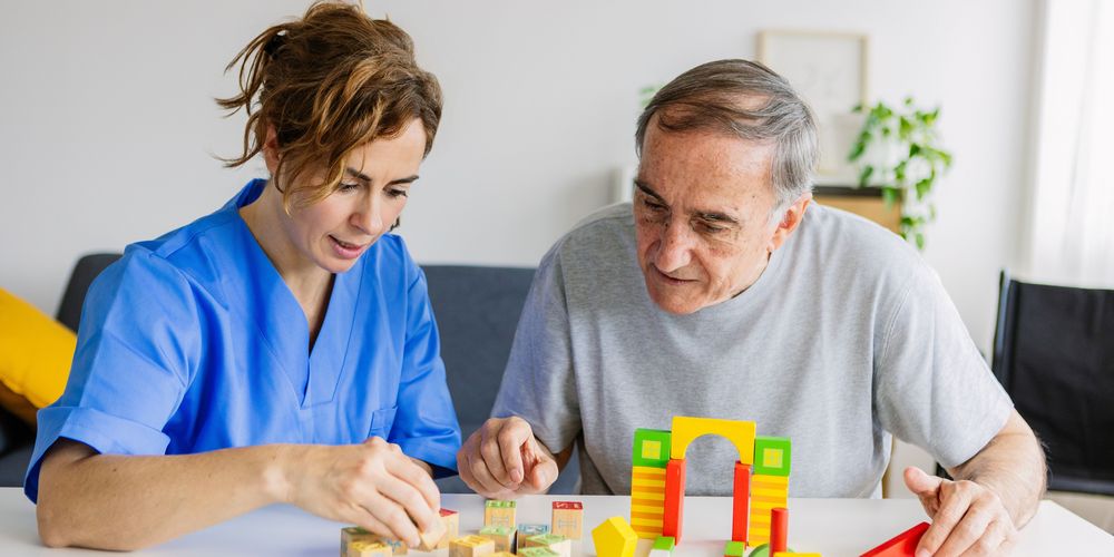 Eine medizinische Fachkraft bei der Therapie eines Patienten in der neurologischen Reha. 